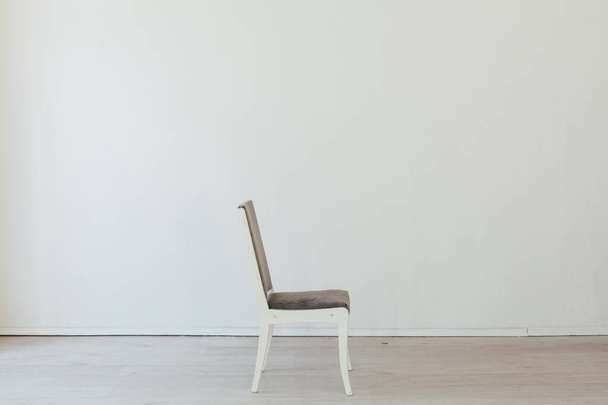 μία γκρι καρέκλα στο εσωτερικό ενός άδειου λευκού δωματίου - Φωτογραφία, εικόνα