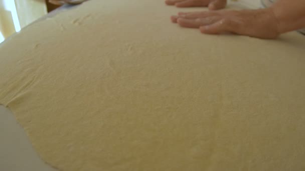 Vrouw handen verspreid de traditionele pizza deeg op tafel. - Video