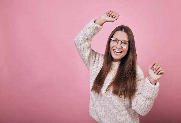 Cool nice girl in transparent glasses in a knitted sweater dancing and having fun - Photo, Image