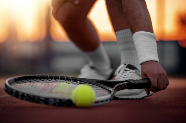 Αθλητισμός. Close up άποψη του ανθρώπου, ρακέτα τένις και μπάλες στο γήπεδο τένις. - Φωτογραφία, εικόνα