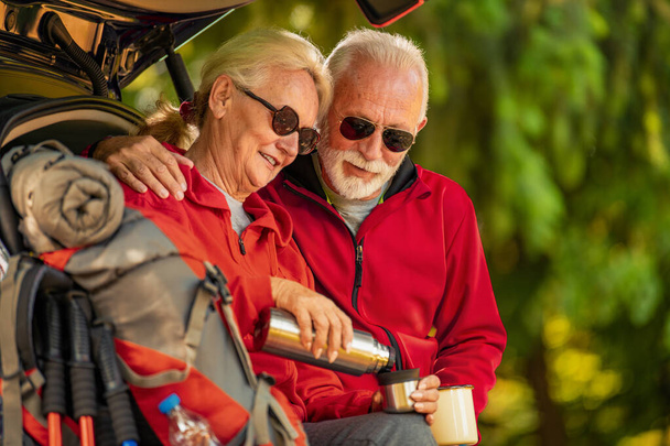 La feliz pareja de ancianos está de excursión en el bosque. Aventura, viajes, senderismo y concepto de personas
. - Foto, imagen