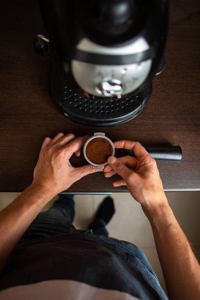 コーヒーメーカーのイメージ、キッチンにコーヒーを注ぐ男の手 - 写真・画像