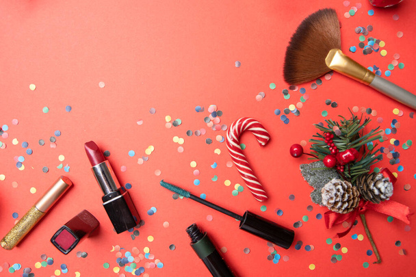 Photo of brushes, confetti, christmas decoration on empty red table - Foto, immagini