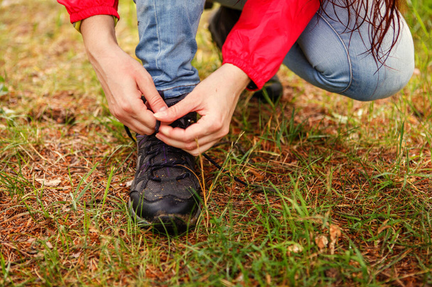 Fotografie dívky vázání tkaničky v obuvi v lese ve dne - Fotografie, Obrázek