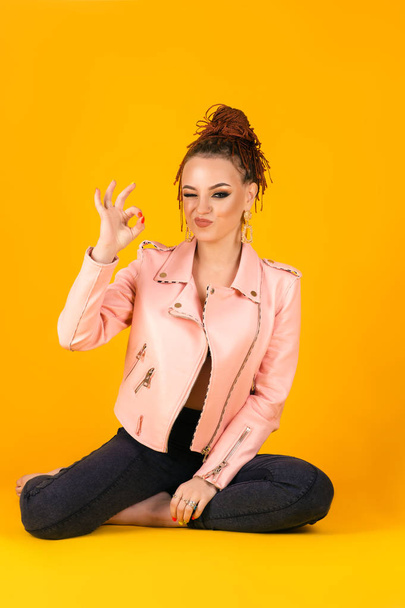 stylish young woman in pink jacket shows ok gesture - Φωτογραφία, εικόνα