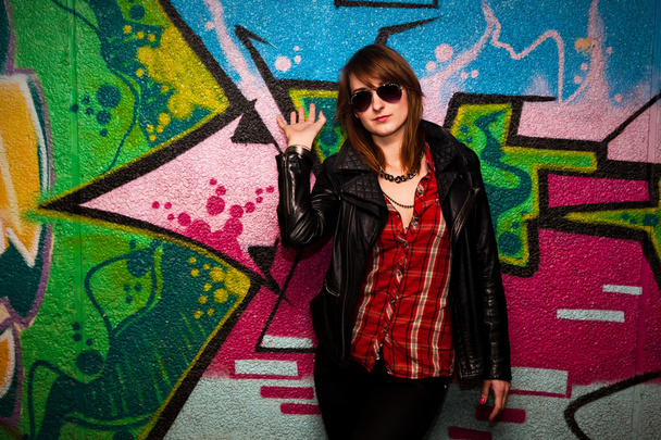 Fashionable girl and colorful graffiti wall - Photo, Image