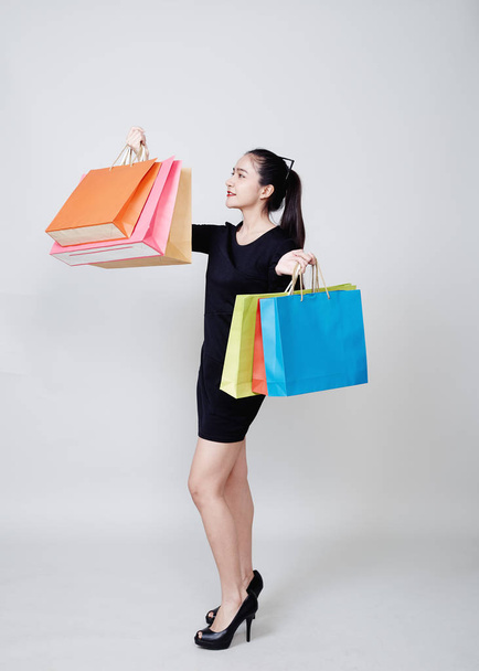 Mulher com sacos de compras em pé sobre branco
 - Foto, Imagem