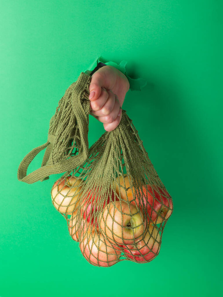 A woman holds reusable Cotton String Portable Shopping Handbag with apples - Foto, immagini