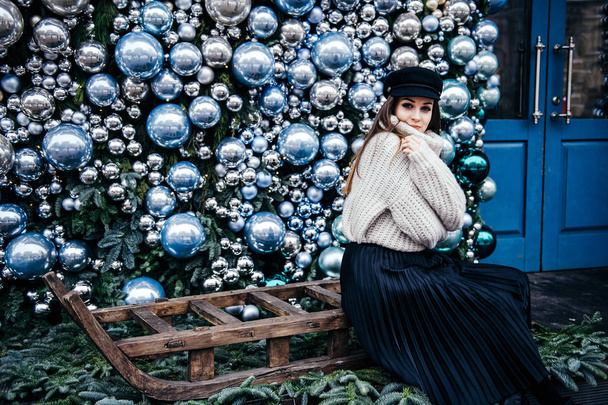 young woman in warm oversize sweater posing near christmas deco - Foto, Imagem