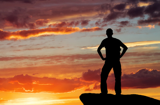 silueta muže na vrcholu hory na pozadí nebe - Fotografie, Obrázek