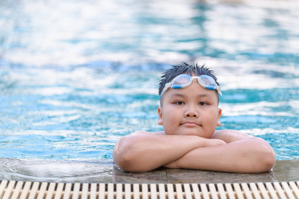 Obeso gordo menino usar óculos e sorrir na piscina
,  - Foto, Imagem