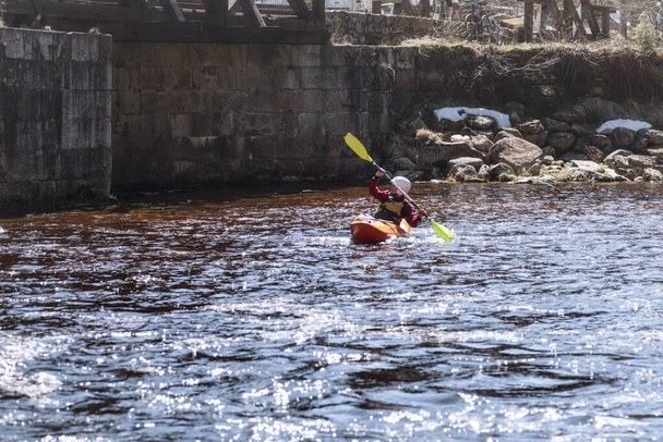 Mujer en el kayak.Mujer en la orilla del río están descansando vertiendo agua de los barcos, llevando kayak a río.Una vista del deporte es kayaking.Soft foco
. - Foto, imagen