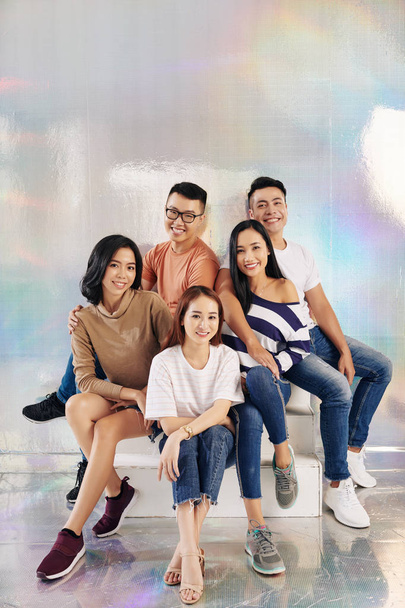 Group of young Vietnamese people posing against holographic background in studio - 写真・画像