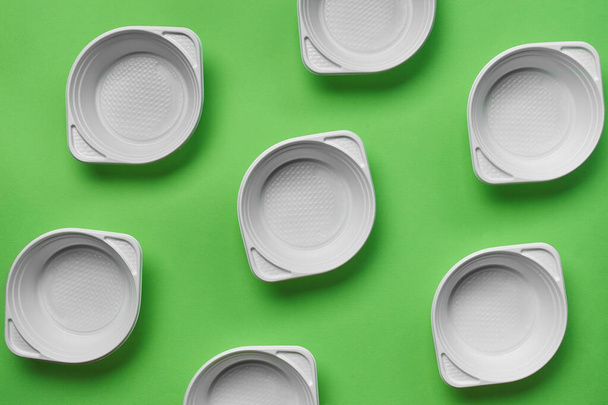 Wit plastic wegwerp servies op groene achtergrond met kopieerruimte. Het concept van picknickgereedschap. Bovenaanzicht. Selectieve focus. Close-up. - Foto, afbeelding