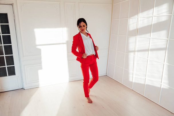 Portrait of a business woman brunette in a red business suit in the office - Fotoğraf, Görsel