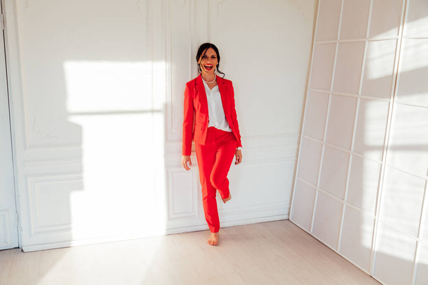オフィスでの赤いビジネススーツのビジネス女性ブルネットの肖像 - 写真・画像