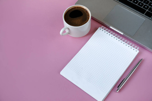 notebook, laptop, pen, black coffee Cup on pink background, copy - Fotó, kép