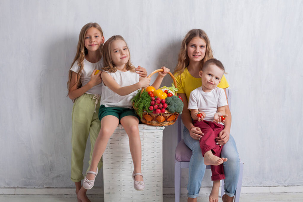 chlapec a tři dívky s košíkem zeleniny a ovoce - Fotografie, Obrázek