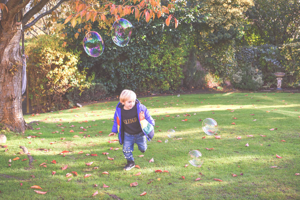 Enfant jouant dehors dans un jardin pendant la journée avec des bulles h
 - Photo, image