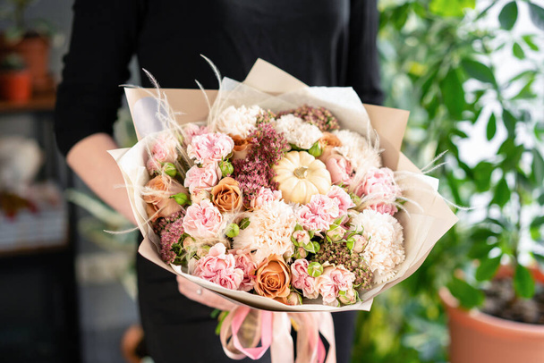 Beyaz ve pembe renk. Kadınların elinde güzel bir buket karışık çiçek. Çiçekçi dükkanındaki çiçekçinin işi. Taze kesilmiş çiçek.. - Fotoğraf, Görsel