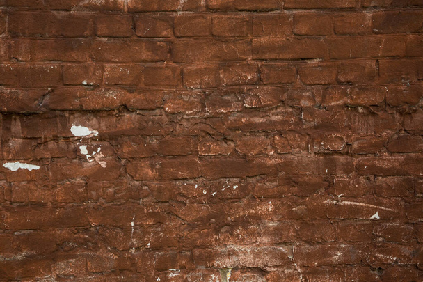 Oude rode bakstenen muur met krassen en corrosie erop. - Foto, afbeelding