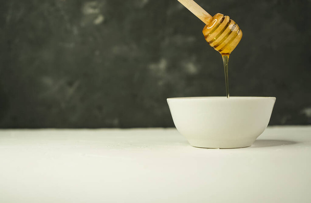 valikoiva keskittyä, pieni Cup luonnon hunajaa ja lusikka
 - Valokuva, kuva