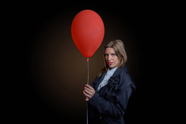 girl in black with a red balloon on a dark background - Fotoğraf, Görsel