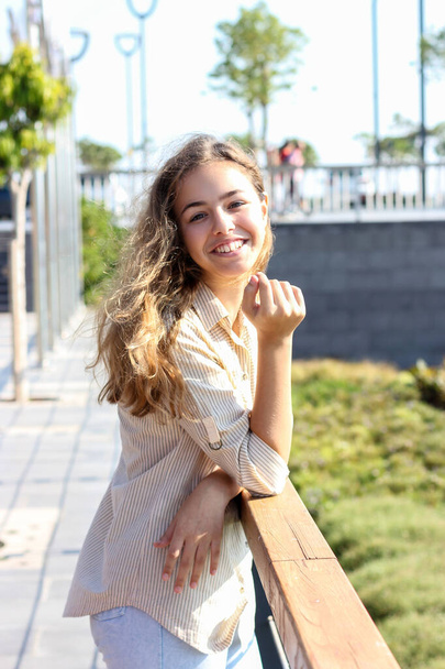 Happy young teenager girl smiling on a sunny day. Charming girl in stylish clothes - Foto, Bild