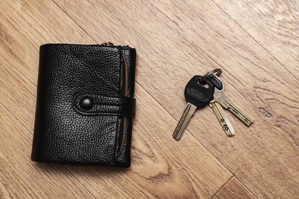 Bando de chaves e carteira preta na mesa de madeira
 - Foto, Imagem