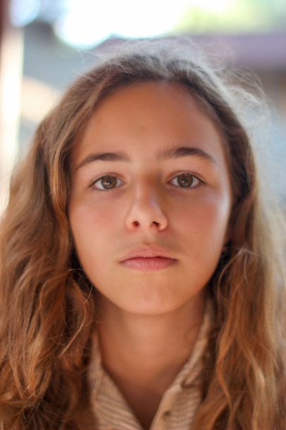 Portrait of a serious young girl with brown eyes. Sad teenager girl looking directly at the camera - Photo, Image