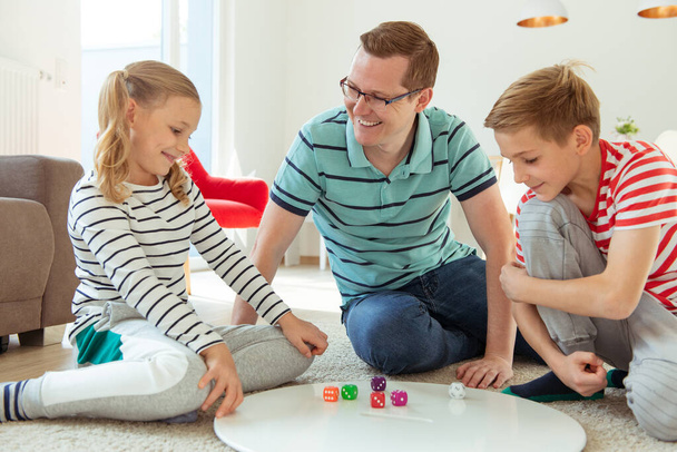 Happy young father plays with his two cheerful siblings children - Foto, Bild