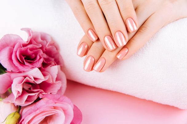 Beautiful Woman Hands with fresh eustoma. Spa and Manicure concept. Female hands with pink manicure. Soft skin skincare concept. Beauty nails. Over beige background - 写真・画像
