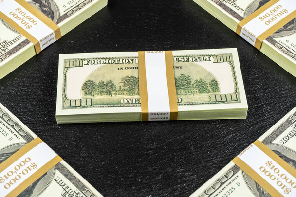 Cincuenta mil dólares en efectivo sobre fondo de piedra negra
 - Foto, imagen