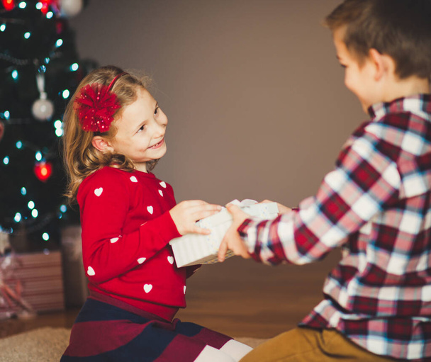 Two happy children in new year eve with presents near New Year T - 写真・画像