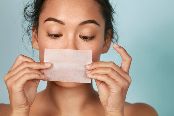Skin care. Woman holding facial oil blotting paper portrait - Foto, Imagen
