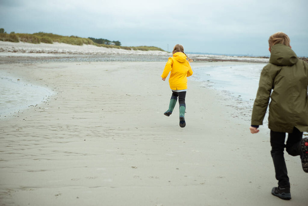 Two happy children running and jumping on water of Baltic sea in - Foto, afbeelding