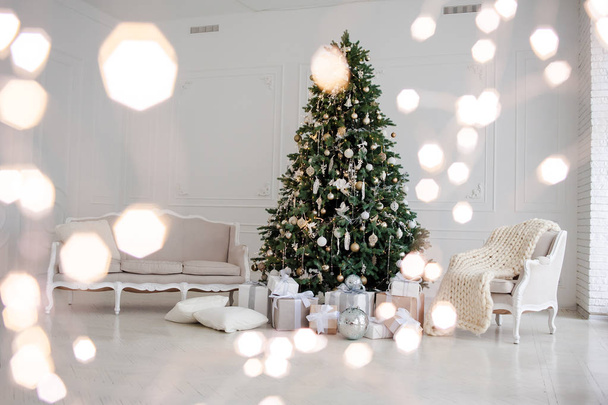 Klassieke kerstmis Nieuwjaar versierd interieur kamer Nieuwjaar boom. Kerstboom met gouden versieringen. Moderne witte klassieke stijl interieur ontwerp - Foto, afbeelding