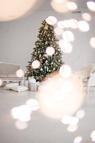 Классическое рождественское новогоднее украшение интерьера новогодней елки. Рождественская елка с золотыми украшениями. Современный интерьер в классическом стиле
 - Фото, изображение