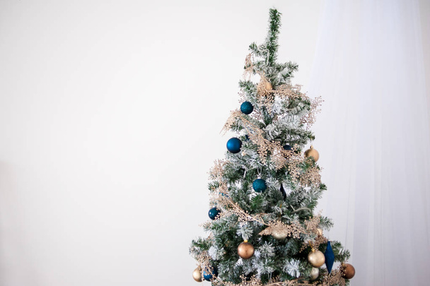 Klasszikus karácsony újév díszített belső szoba Újévi fa. Karácsonyfa arany díszítéssel. Modern fehér klasszikus stílusú belsőépítészet - Fotó, kép