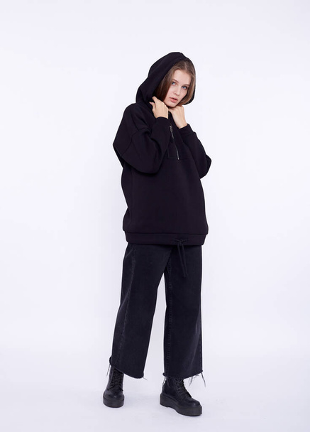 Young girl wearing blank and oversize black long hoody. White background - Valokuva, kuva