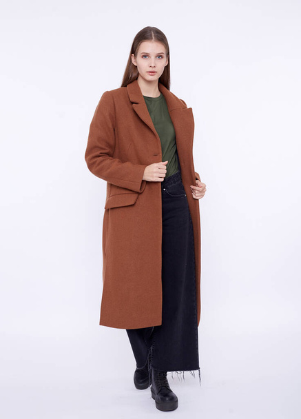 Beautiful fashion model in long brown coat isolated on white background - 写真・画像