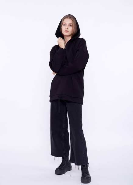 Young girl wearing blank and oversize black long hoody. White background - Foto, imagen