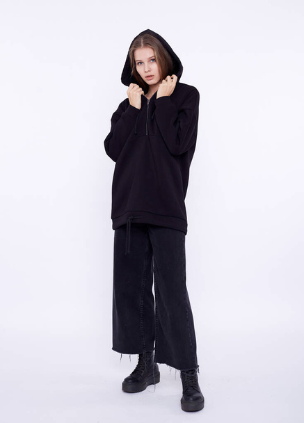 Young girl wearing blank and oversize black long hoody. White background - Fotoğraf, Görsel