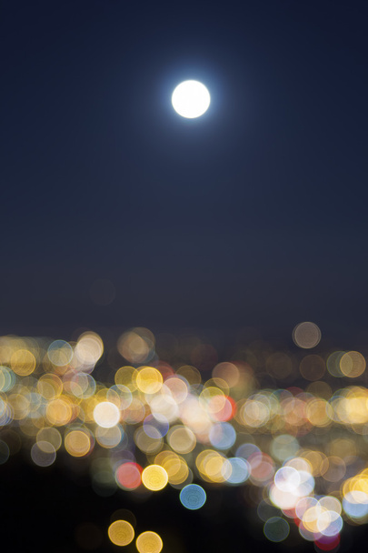 Lever de pleine lune sur les lumières floues de la ville
 - Photo, image