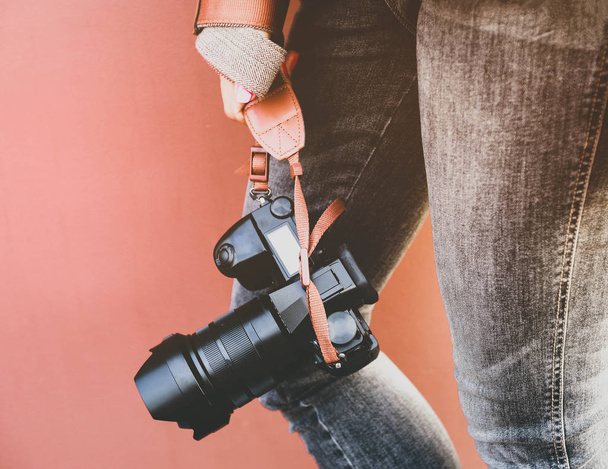 Woman hand holds the camera on brown background - Valokuva, kuva