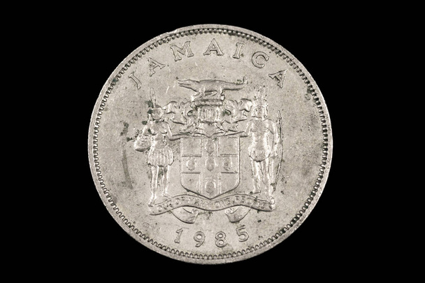 Крупный план, макро изображение старой ямайской монеты двадцать пять центов изолированы на черном фоне
 - Фото, изображение