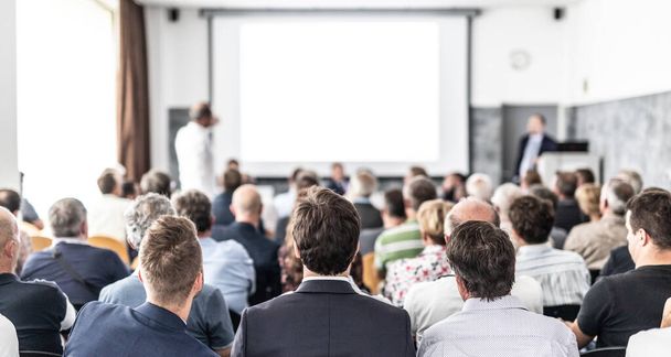 I have a question. Group of business people sitting in conference hall. Businessman raising his arm. Conference and Presentation. Business and Entrepreneurship - Photo, Image