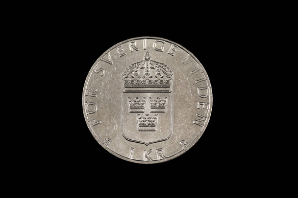 黒の背景に隔離されたスウェーデンの1クローネ硬貨のクローズアップ、マクロ画像 - 写真・画像