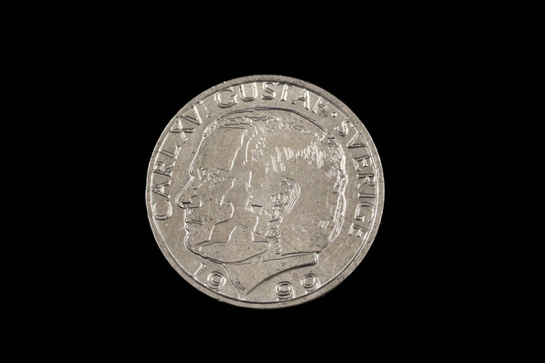 Um close-up, imagem macro de uma moeda de uma coroa sueca isolada em um fundo preto
 - Foto, Imagem