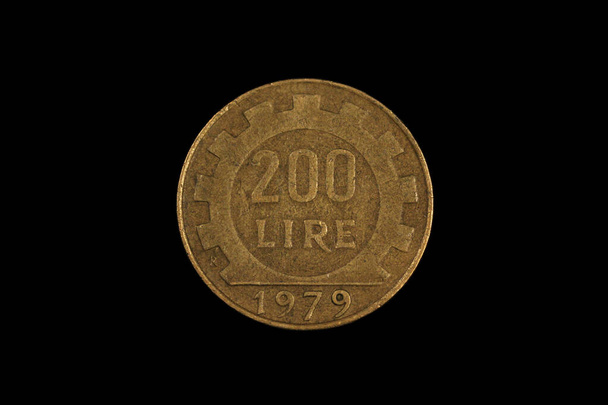 A close up image, shot in macro of an old Italian two hundred lira coin, shot against a black background - Photo, Image